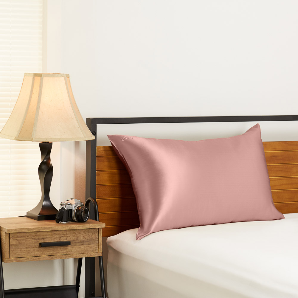 Rose gold Blissy silk pillowcase in a bedroom