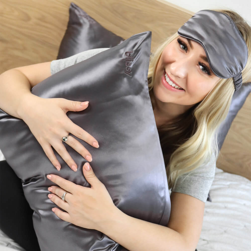 Woman hugging a grey Blissy silk pillowcase