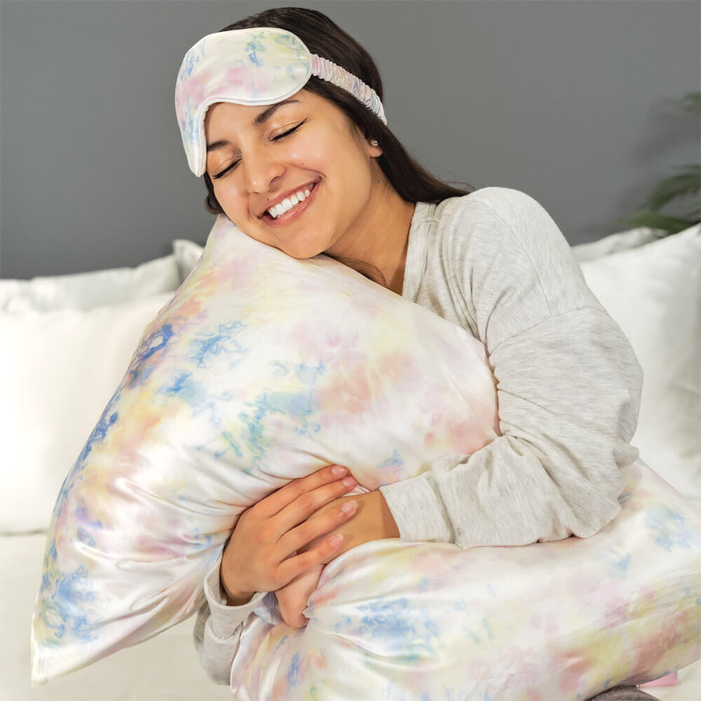 Woman hugging a tie-dye Blissy silk pillowcase